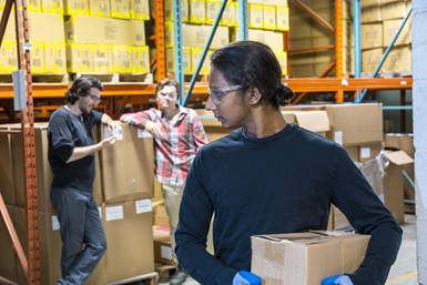 Men in warehouse judging female coworker - Racial Discrimination